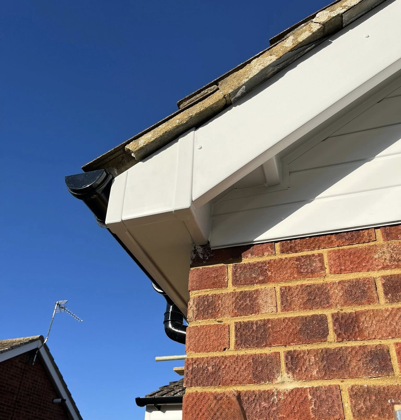 558781168_1561312824830129_8093596711256202900_n Fascia and soffit installation on brick house in Milton Keynes showing white UPVC boards and black guttering